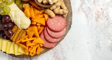 Savory Snack Board Featuring Assorted Nuts Chips Cheeses and Sausages